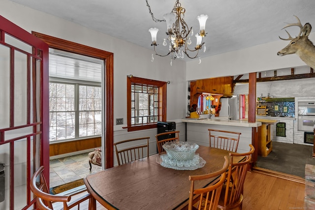 dining space featuring a notable chandelier and light wood-type flooring