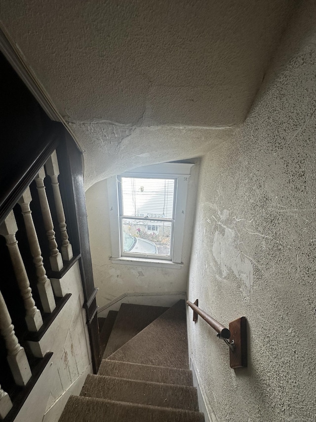 stairs with a textured ceiling