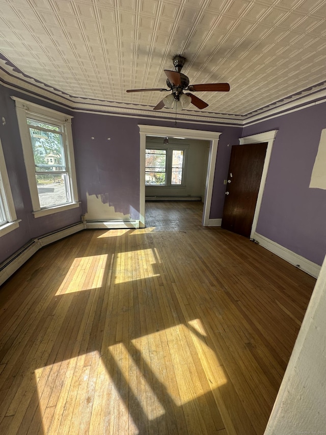 spare room with ceiling fan, hardwood / wood-style floors, a baseboard radiator, and ornamental molding