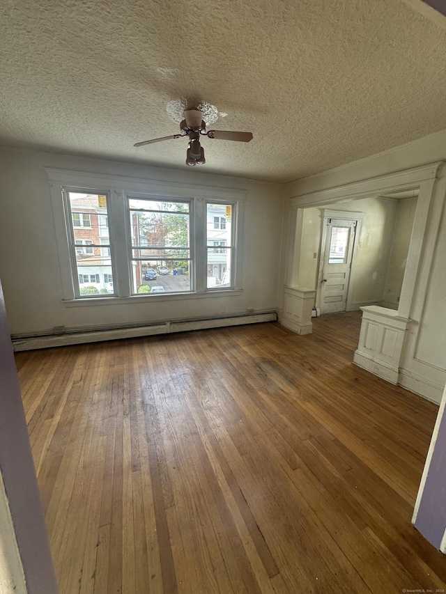 spare room featuring hardwood / wood-style floors, a textured ceiling, ceiling fan, and a baseboard heating unit