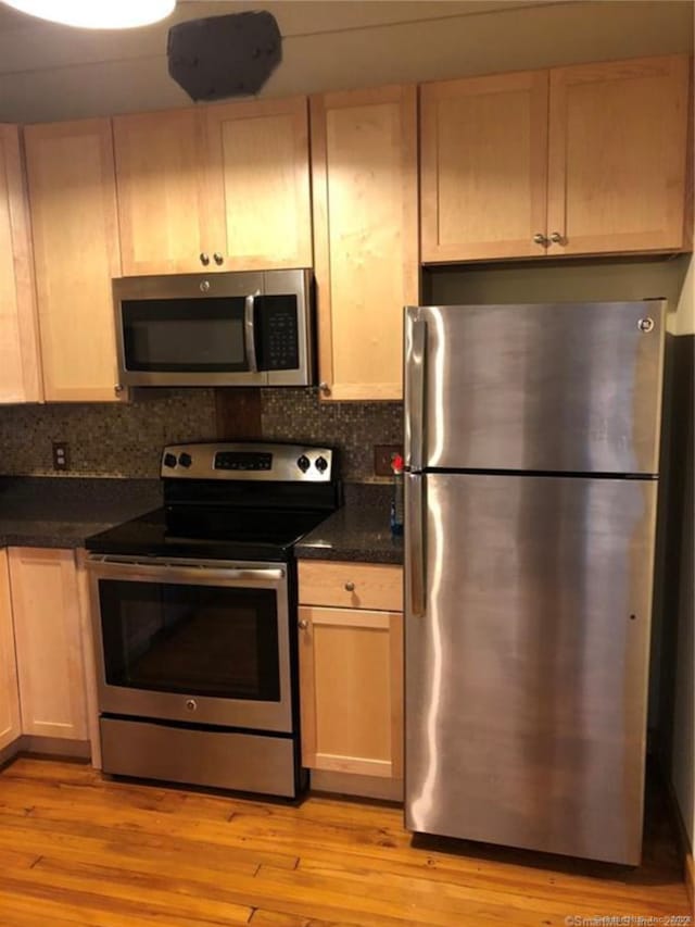 kitchen with light brown cabinetry, stainless steel appliances, and light wood-type flooring