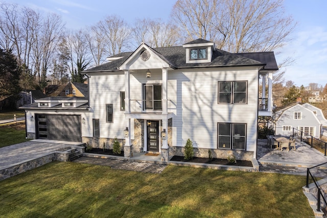 view of front facade featuring a front yard, a balcony, a garage, and a patio area