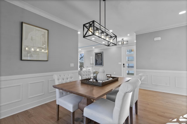 dining room with ornamental molding and light hardwood / wood-style flooring