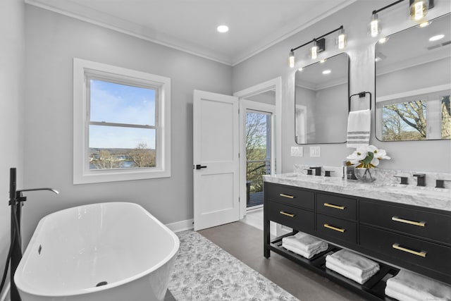 bathroom featuring crown molding, a tub, and a wealth of natural light