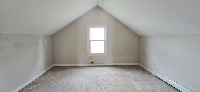 additional living space with light colored carpet, vaulted ceiling, and a baseboard heating unit