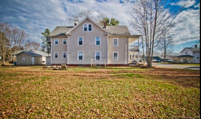 rear view of property with a yard