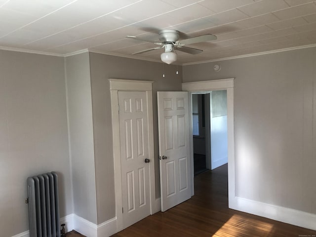 unfurnished bedroom with ceiling fan, dark hardwood / wood-style floors, ornamental molding, and radiator