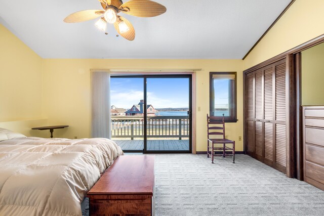 bedroom with access to outside, ceiling fan, a water view, and light colored carpet