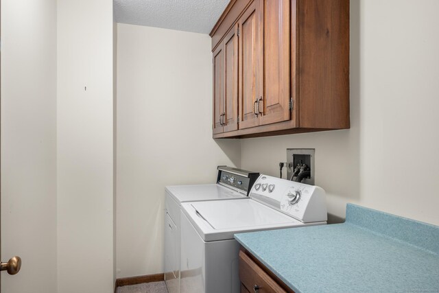 laundry room featuring cabinets, a textured ceiling, and washing machine and dryer