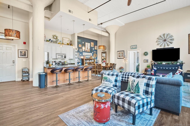 living room featuring a high ceiling and hardwood / wood-style flooring