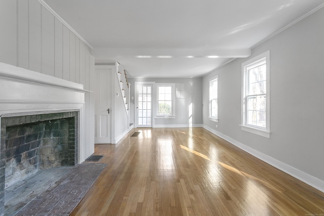 unfurnished living room with wood-type flooring and crown molding