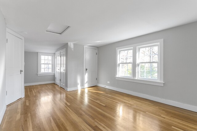 spare room with light wood-type flooring and a healthy amount of sunlight