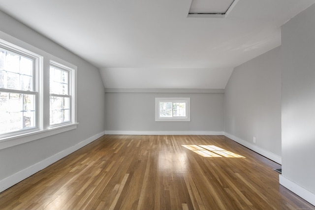 bonus room with hardwood / wood-style floors and vaulted ceiling