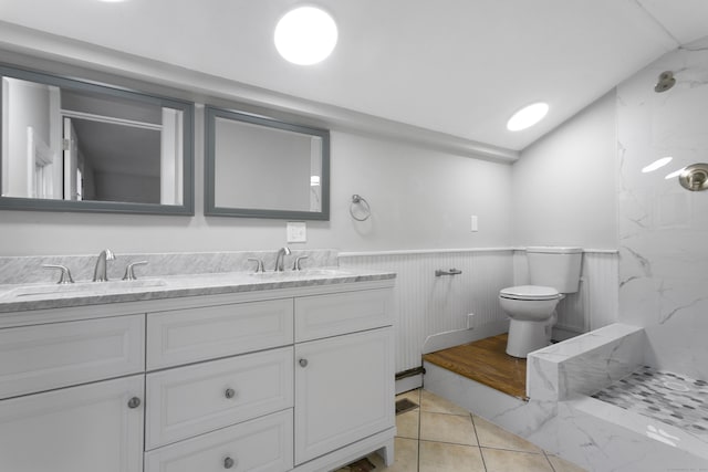 bathroom with tile patterned floors, vanity, tiled shower, toilet, and lofted ceiling