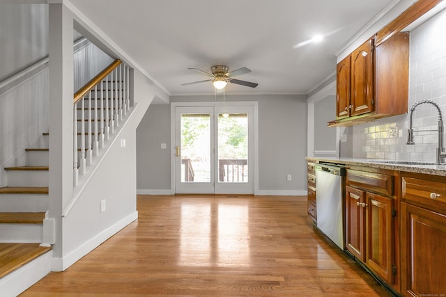 kitchen with dishwasher, light hardwood / wood-style floors, ornamental molding, and sink