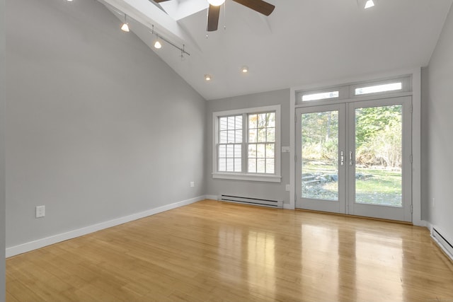 unfurnished room with a baseboard radiator, vaulted ceiling, ceiling fan, and light hardwood / wood-style flooring