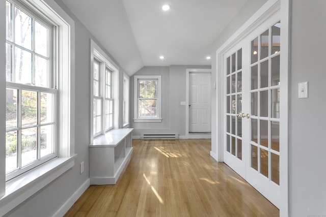 unfurnished sunroom featuring vaulted ceiling, french doors, and a baseboard radiator