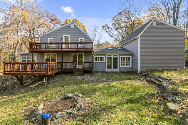 rear view of property with a wooden deck and a yard