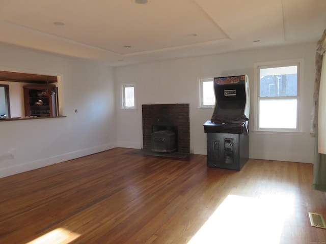 276 Parker Farms Rd, Wallingford, CT 06492 - unfurnished living room featuring a tray ceiling, a wood stove, and wood finished floors