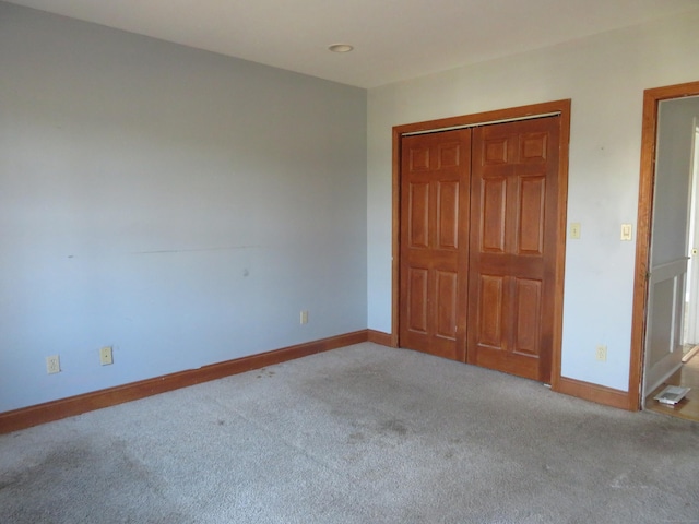 unfurnished bedroom featuring baseboards, carpet floors, a closet, and visible vents