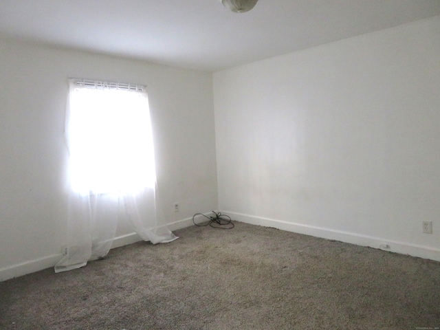 spare room featuring baseboards and carpet floors