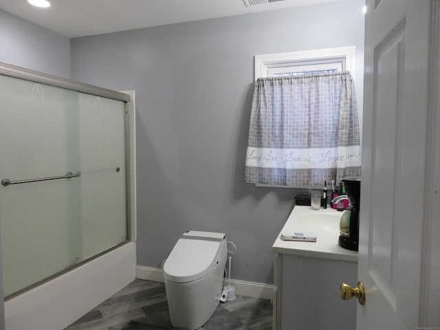 full bath with visible vents, baseboards, bath / shower combo with glass door, toilet, and vanity