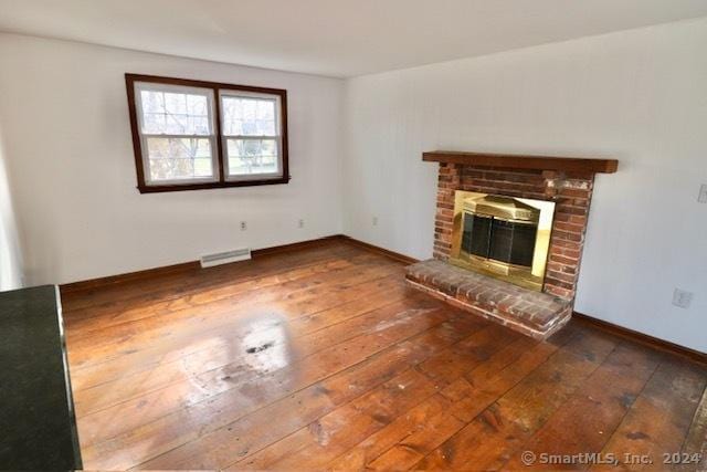 unfurnished living room featuring a fireplace and dark wood-type flooring