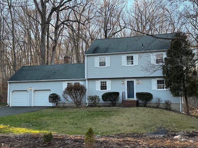 view of front of property with a garage and a front lawn