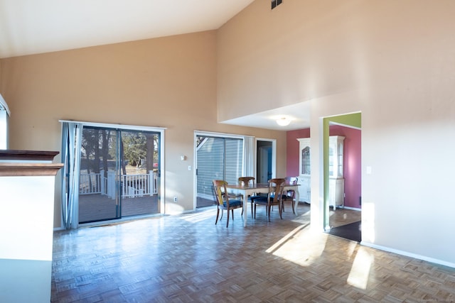 unfurnished dining area featuring a high ceiling and parquet floors