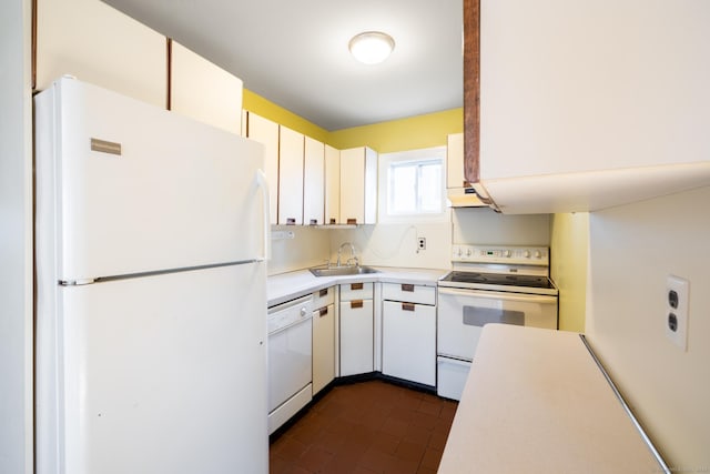 kitchen featuring white appliances, sink, dark tile patterned floors, range hood, and white cabinetry