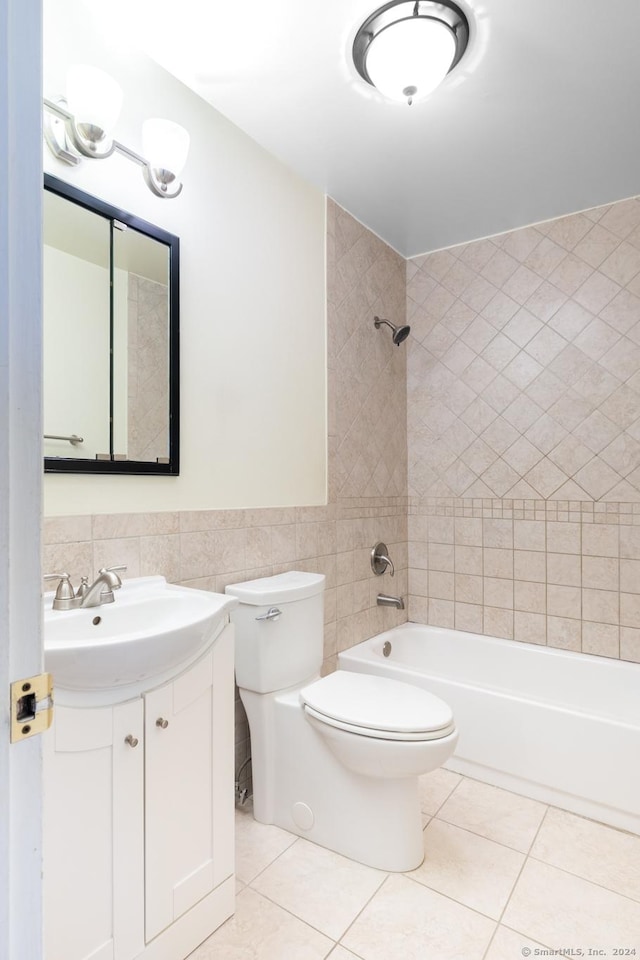 full bathroom with tile patterned floors, toilet, tile walls, and tiled shower / bath