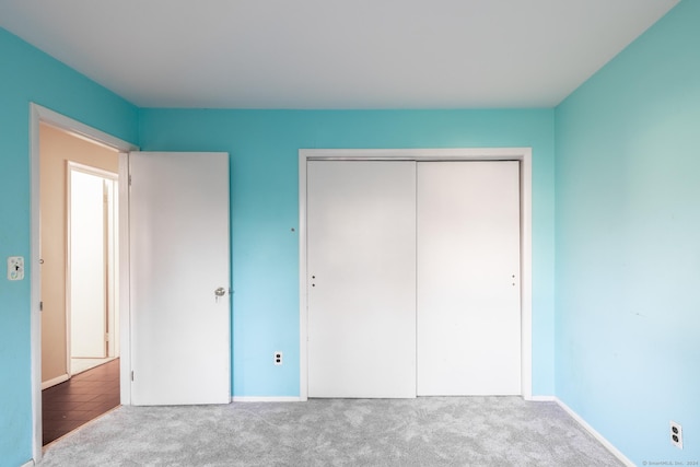 unfurnished bedroom featuring carpet and a closet