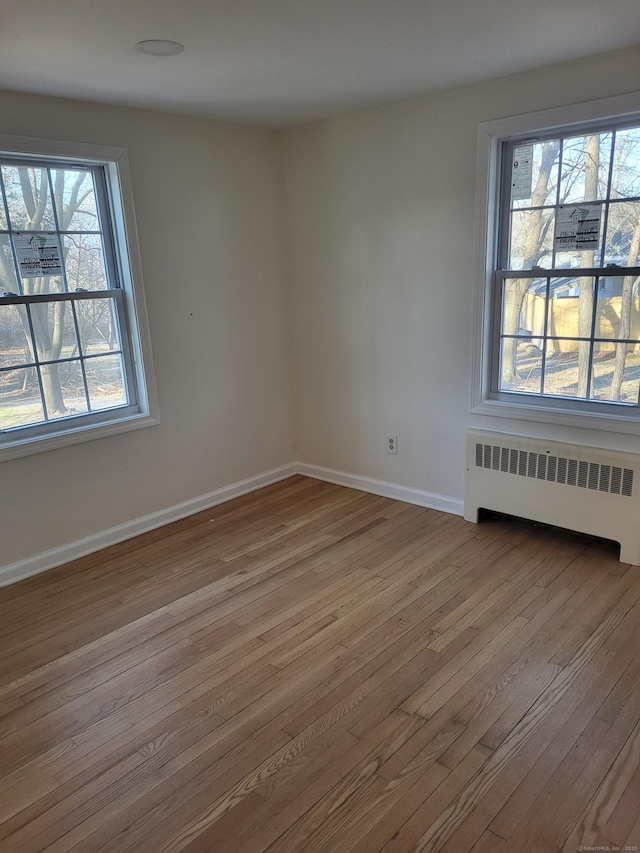 empty room with radiator and light wood-type flooring