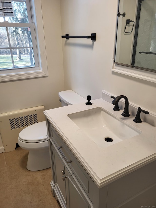 bathroom featuring tile patterned flooring, vanity, radiator, and toilet