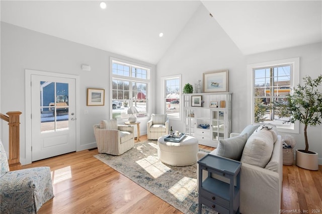 living room featuring high vaulted ceiling and light wood-type flooring