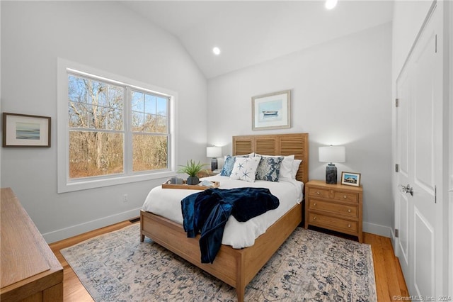bedroom featuring lofted ceiling and light hardwood / wood-style floors