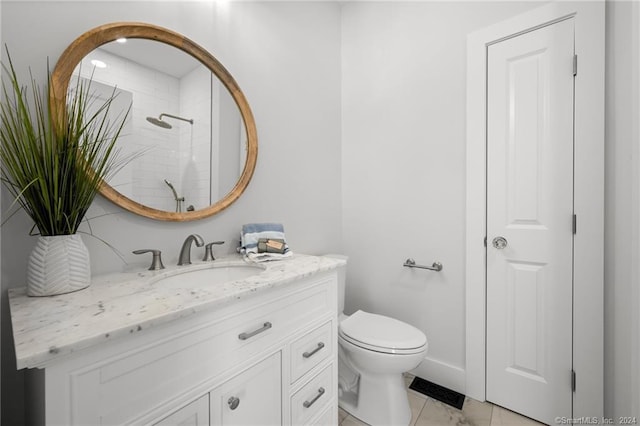 bathroom with vanity, toilet, and a shower