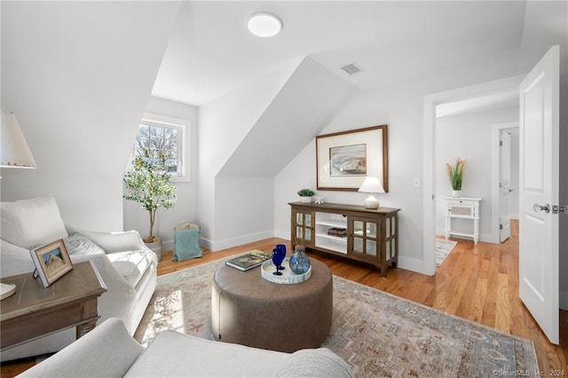 living room featuring lofted ceiling and hardwood / wood-style floors
