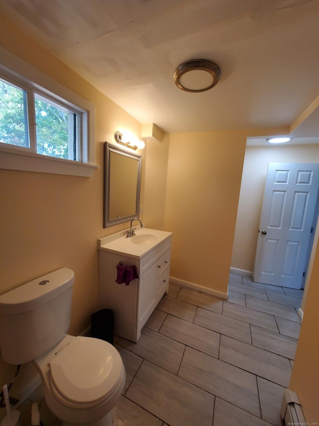 bathroom featuring vanity, toilet, and a baseboard heating unit