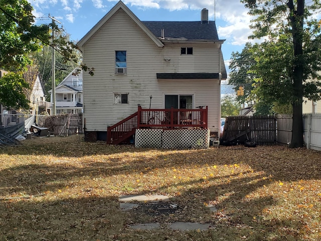 back of property featuring a wooden deck and a lawn