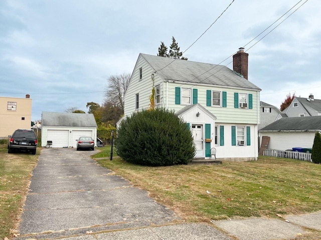 view of front of home with an outdoor structure, a front yard, and a garage