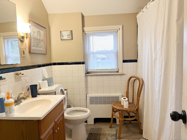 24 Brewster St, Stratford, CT 06614 - bathroom featuring radiator, tile walls, vanity, a wainscoted wall, and curtained shower