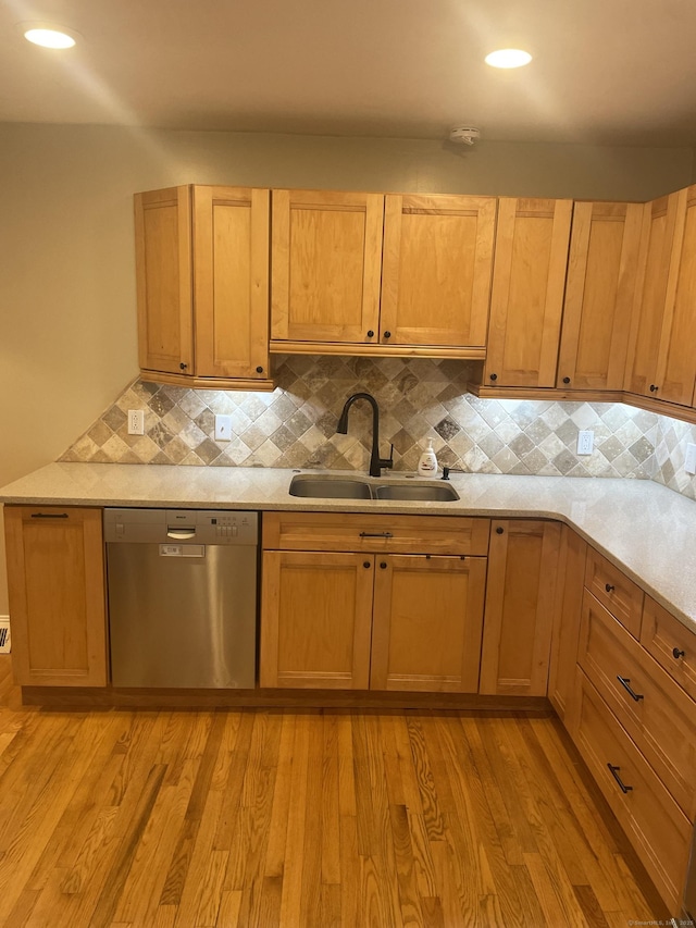 kitchen featuring sink, stainless steel dishwasher, decorative backsplash, light brown cabinetry, and light wood-type flooring