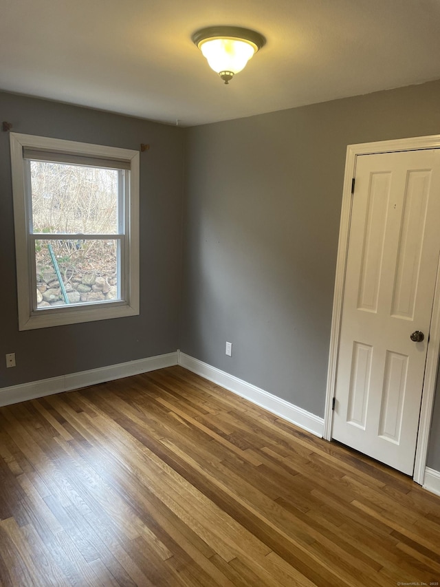 unfurnished room with wood-type flooring