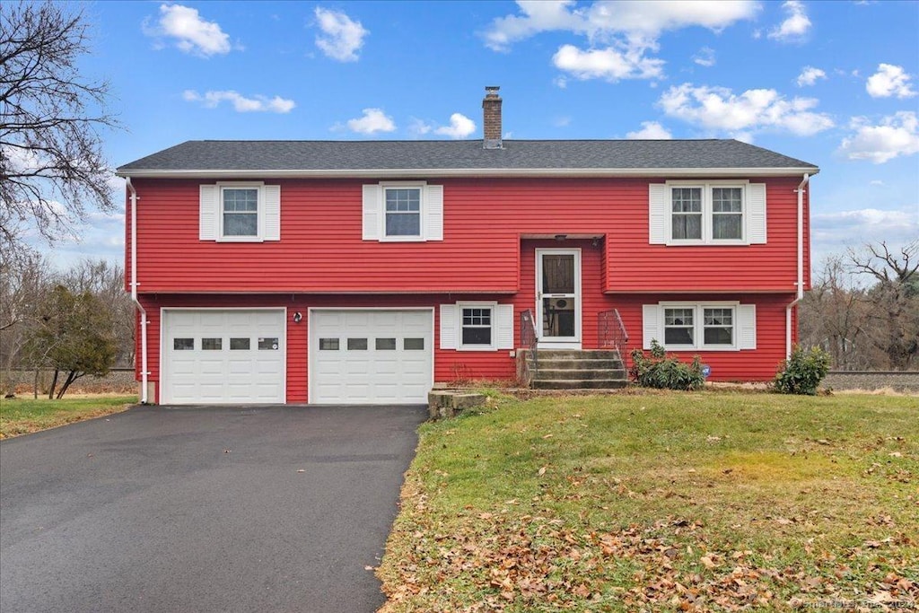 split foyer home featuring a garage and a front lawn