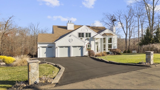 view of front of home with a front yard and a garage