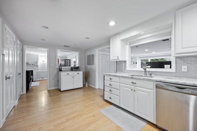 kitchen with dishwasher, white cabinets, sink, light wood-type flooring, and tasteful backsplash