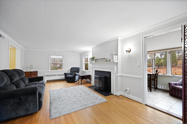 living room featuring hardwood / wood-style flooring, plenty of natural light, radiator, and crown molding