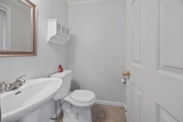 bathroom featuring toilet, ornamental molding, and sink