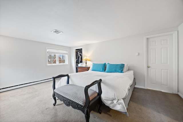 bedroom with baseboard heating, a spacious closet, a closet, and dark carpet